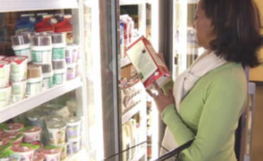 A woman reading the food labels at a grocery store