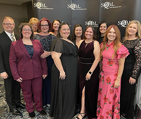 11 employees stand together at BCBSKS call center customer service awards