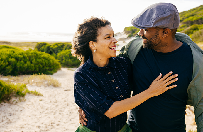 Couple in their 40's strolling arm-in-arm on a beach path
