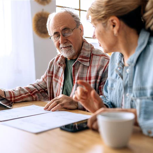 Retired couple review documents together at kitchen table