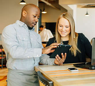 Two restaurant employees use digital tools to optimize and control expenses