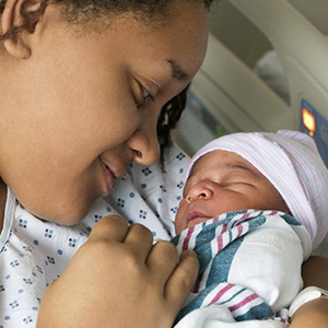 mother looks affectionately at her new born child 