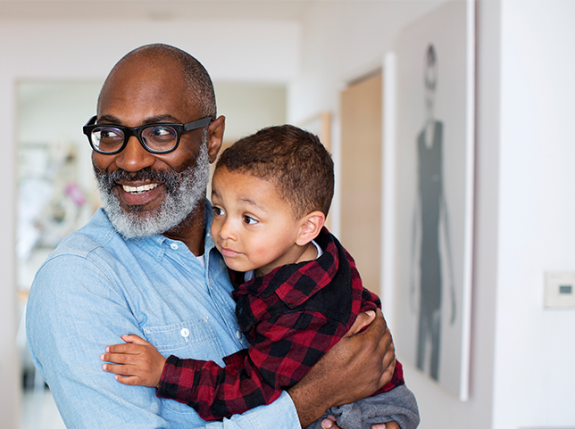 grandparent smiles while holding young grandchild