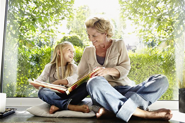 grandparent reads with smiling grandchild