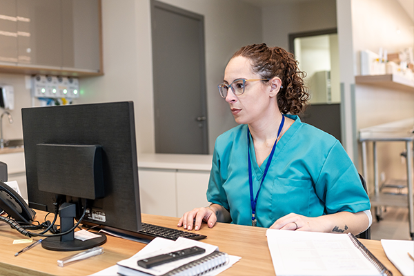 health care provider works on desktop computer