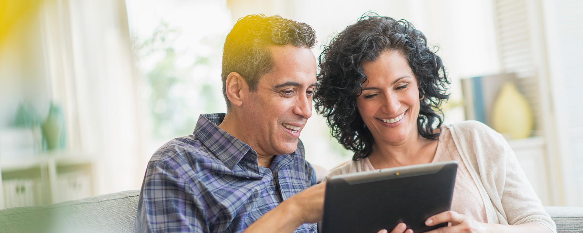 Happy couple looking at tablet