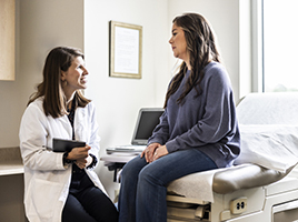 A doctor talks to a patient in an exam room