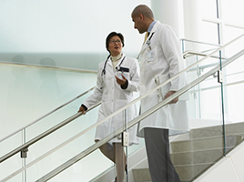Two doctors talking while descending stairs