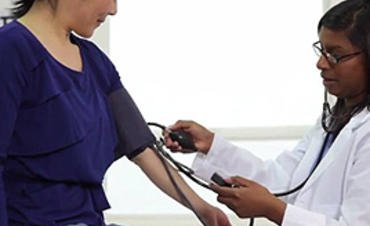 A doctor taking their patient's blood pressure