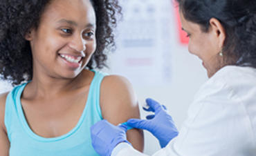 Doctor giving teen an immunization