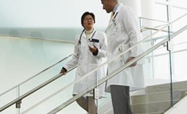 Two doctors talking while descending stairs