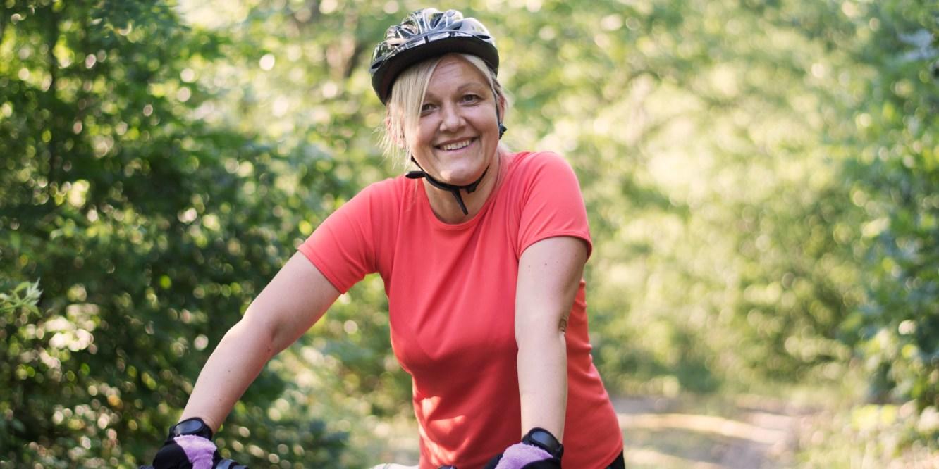 A woman biking out in nature.