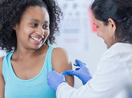 Doctor giving teen an immunization
