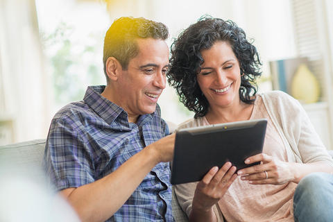 Happy couple looking at tablet